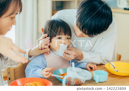 一家三口正在享用義大利麵午餐。 142223809