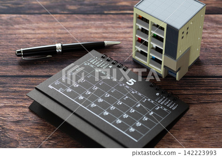 五月的黑色日曆和一棟公寓樓模型。 五月的黑色日曆和一棟公寓樓模型。 142223993