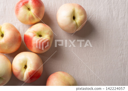 Fresh organic nectarines on white cotton fabric background, Top view Fresh organic nectarines on white cotton fabric background, Top view 142224057