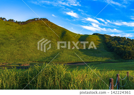 Mount Kameyama and Okame Pond bathed in the setting sun, Soni Plateau, 35mm, blank copy space at the top, horizontal composition with blue sky on the right, suitable for B1 poster. 142224361