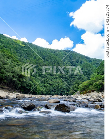 A clear blue sky and a pristine mountain stream. A clear blue sky and a pristine mountain stream. 142225574