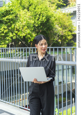 Business woman with computer laptop working outside in the park. Female professional businesswoman working outdoors. Business woman with computer laptop working outside in the park. Female professional businesswoman working outdoors. 142226051
