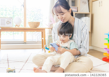 孩子媽媽看著智慧型手機 142226365