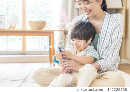 孩子媽媽看著智慧型手機 142226366