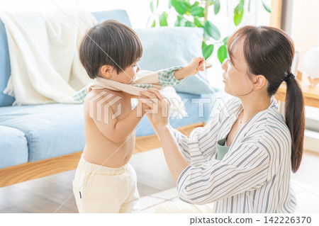 Mom changing her toddler's clothes Mom changing her toddler's clothes 142226370