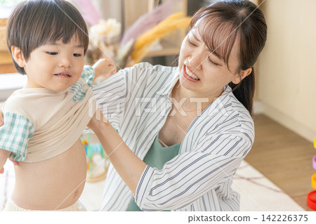 Moms who are frustrated because they can't get their children dressed properly. Moms who are frustrated because they can't get their children dressed properly. 142226375