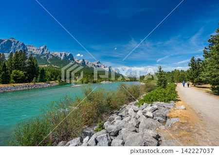 Summer scenery of Higashikawa Town's Friendship Promenade, Bow River, and Mount Rundle. Canmore, Alberta, Canada. Summer scenery of Higashikawa Town's Friendship Promenade, Bow River, and Mount Rundle. Canmore, Alberta, Canada. 142227037