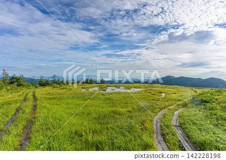 A spectacular view of the ponds and high-altitude wetlands at the summit of Mt. Nakamon, reflecting the summer blue sky. A spectacular view of the ponds and high-altitude wetlands at the summit of Mt. Nakamon, reflecting the summer blue sky. 142228198