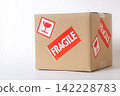 Cardboard box with a "Fragile" sticker on it. 142228783