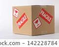 Cardboard box with a "Fragile" sticker on it. 142228784
