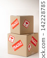Cardboard box with a "Fragile" sticker on it. 142228785