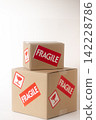 Cardboard box with a "Fragile" sticker on it. 142228786