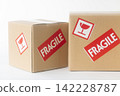 Cardboard box with a "Fragile" sticker on it. 142228787
