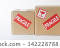 Cardboard box with a "Fragile" sticker on it. 142228788