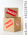 Cardboard box with a "Fragile" sticker on it. 142228791