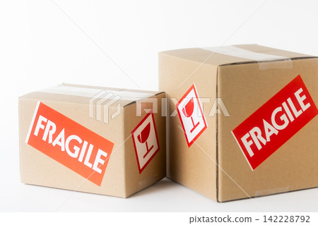 Cardboard box with a "Fragile" sticker on it. Cardboard box with a "Fragile" sticker on it. 142228792