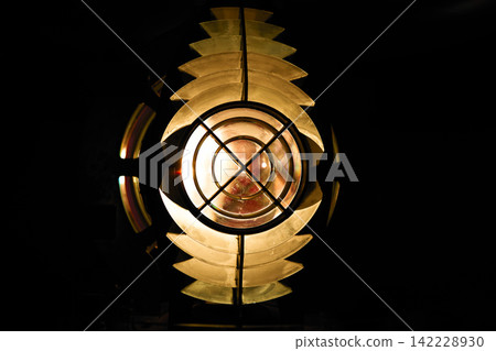 A close-up of the lighthouse's golden Fresnel lens. A close-up of the lighthouse's golden Fresnel lens. 142228930
