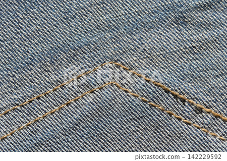 Light Blue Denim Fabric With Double Golden Seam Stitching Forming Angled Lines Across Frame Light Blue Denim Fabric With Double Golden Seam Stitching Forming Angled Lines Across Frame 142229592