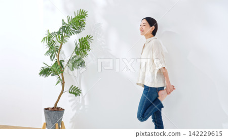 一位中年女性正在伸展身體。健康、醫療保健、健康、身體照護、休閒、生活方式、微笑 142229615