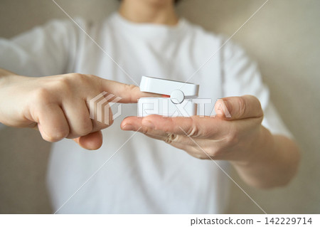 Finger pressing button on pulse oximeter illustrating operation of healthcare monitoring equipment Finger pressing button on pulse oximeter illustrating operation of healthcare monitoring equipment 142229714