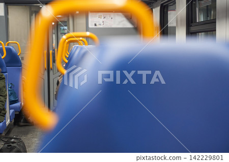 Train Carriage Blue Seat Back With Yellow Handrail In Foreground Showing Blurred Aisle Perspective Train Carriage Blue Seat Back With Yellow Handrail In Foreground Showing Blurred Aisle Perspective 142229801