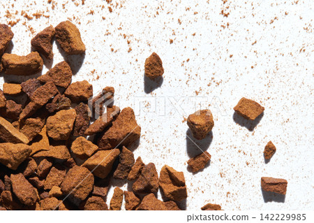 Instant Coffee Granules Clustered And Scattered On White Background With Powdery Residue Instant Coffee Granules Clustered And Scattered On White Background With Powdery Residue 142229985