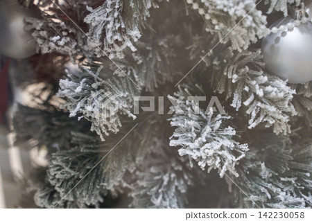 Frosted Pine Branches With Artificial Snow And Silver Bauble Closeup On Decorated Christmas Tree 142230058