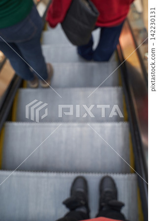 People Riding Escalator Viewed Above Showing Feet On Metal Treads Steps And Moving Handrail People Riding Escalator Viewed Above Showing Feet On Metal Treads Steps And Moving Handrail 142230131