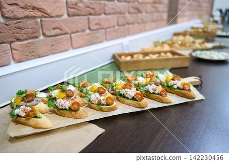 Bruschetta Cherry Tomato Herb Creamy Spread On Wooden Board In Indoor Buffet Setup With Brick Wall Bruschetta Cherry Tomato Herb Creamy Spread On Wooden Board In Indoor Buffet Setup With Brick Wall 142230456