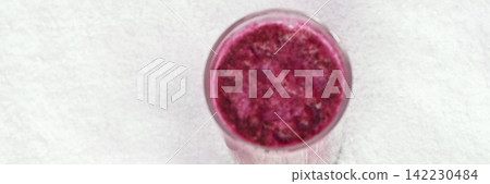Glass With Purple Smoothie Placed On White Textured Surface From Overhead Perspective Showing 142230484