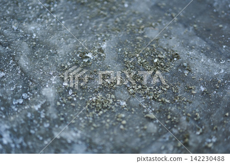 Closeup Of Frozen Concrete Tile With Concentrated Salt Granules And Mineral Residue On Icy Surface Closeup Of Frozen Concrete Tile With Concentrated Salt Granules And Mineral Residue On Icy Surface 142230488