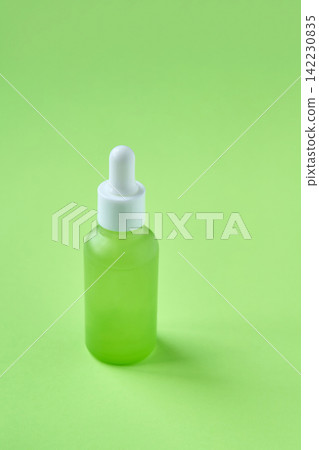 Green Frosted Dropper Bottle Standing Upright With White Cap And Pipette On Monochrome Green Studio 142230835