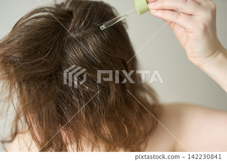 Person Tilting Head Forward Applying Scalp Oil With Dropper To Roots Exposing Scalp And Textured 142230841