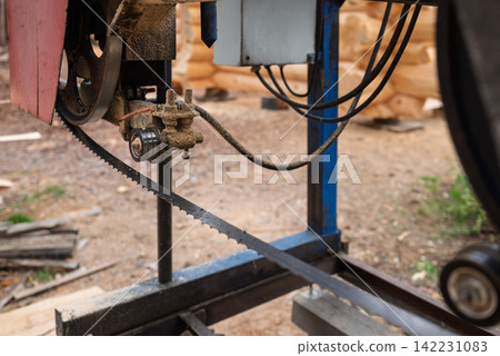 Close-up of a machine for sawing pine logs at a sawmill Close-up of a machine for sawing pine logs at a sawmill 142231083