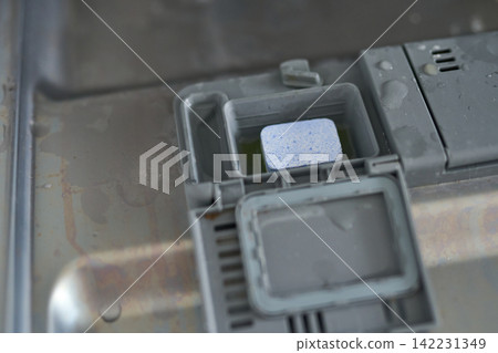 Closeup Of Dishwasher Detergent Holder With Tablet Inside And Water Droplets On Stainless Steel Closeup Of Dishwasher Detergent Holder With Tablet Inside And Water Droplets On Stainless Steel 142231349