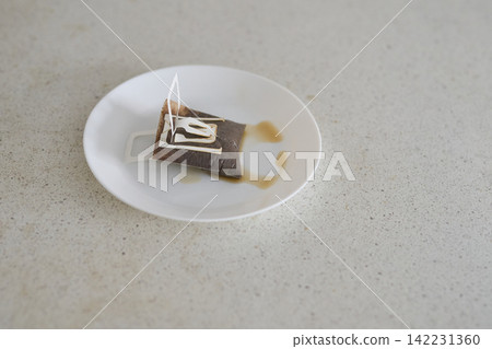 Used Paper Drip Coffee Filter Resting On White Plate With Coffee Stains On Speckled Countertop 142231360