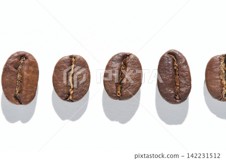Coffee Bean Aligned In Single Horizontal Row Casting Distinct Shadows On White Studio Background Coffee Bean Aligned In Single Horizontal Row Casting Distinct Shadows On White Studio Background 142231512