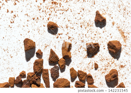 Instant Coffee Granules Spaced And Scattered Across White Surface With Fine Powder Traces Instant Coffee Granules Spaced And Scattered Across White Surface With Fine Powder Traces 142231545