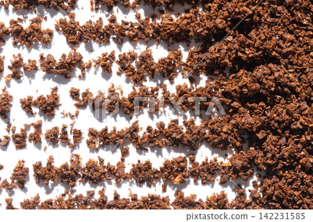 Coffee Grounds Scattered In Linear Patterns On White Background With Strong Directional Light Coffee Grounds Scattered In Linear Patterns On White Background With Strong Directional Light 142231585