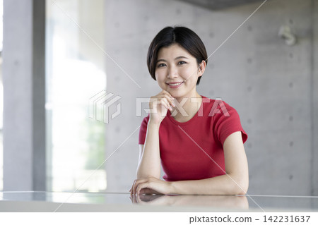 一個二十多歲的女人微笑著看著相機的畫像 一個二十多歲的女人微笑著看著相機的畫像 142231637