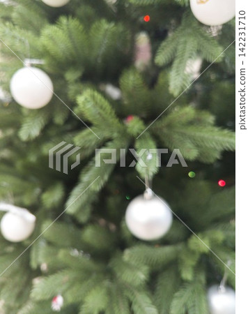 Christmas Tree Branches Decorated With White Baubles And Blurred Bokeh Lights In Indoor Holiday Christmas Tree Branches Decorated With White Baubles And Blurred Bokeh Lights In Indoor Holiday 142231710