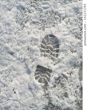Single Boot Print In Fresh Snow On Pavement Creating Defined Tread Imprint And Icy Textured Surface Single Boot Print In Fresh Snow On Pavement Creating Defined Tread Imprint And Icy Textured Surface 142231765