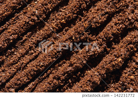 Ridged Ground Coffee Surface With Parallel Furrows Forming Diagonal Texture Closeup Crumbly 142231772