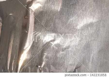 Crumpled Aluminum Foil Metallic Texture Background With Shiny Silver Reflective Surface Crumpled Aluminum Foil Metallic Texture Background With Shiny Silver Reflective Surface 142231858