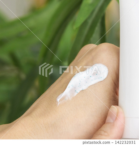 Back Of Hand Showing Smear Of Exfoliating Cream With Visible Microbeads Held Next To White Tube Back Of Hand Showing Smear Of Exfoliating Cream With Visible Microbeads Held Next To White Tube 142232031