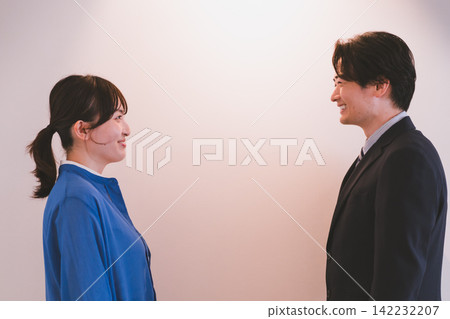 A photo of a man and woman who look like they might be starting a workplace romance. A photo of a man and woman who look like they might be starting a workplace romance. 142232207