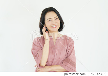 Portrait of a middle-aged Japanese woman against a white background Portrait of a middle-aged Japanese woman against a white background 142232313