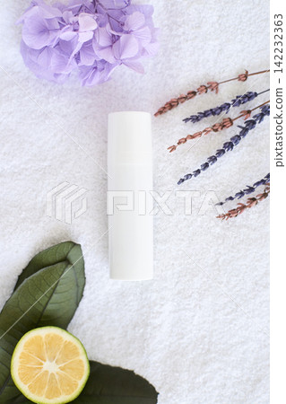 Natural skincare concept with cream bottle, lavender, hydrangea, leaves, and citrus on white 142232363