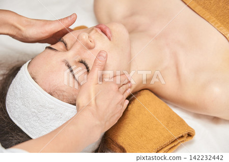 Young Caucasian Female Receiving Relaxing Facial Massage At Spa For Rejuvenation And Skincare Young Caucasian Female Receiving Relaxing Facial Massage At Spa For Rejuvenation And Skincare 142232442