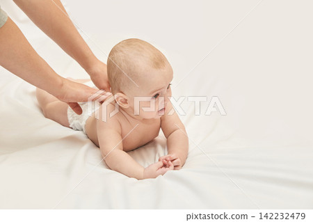 Caucasian Baby Receiving Gentle Massage On Soft White Blanket With Tender Care And Parental Love Caucasian Baby Receiving Gentle Massage On Soft White Blanket With Tender Care And Parental Love 142232479